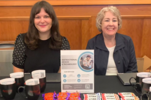 Photo of IDT staff, seated at table with swag, welcoming faculty to fall 2024 semester